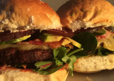 Grassfed beefburgers. With streaky bacon, beetroot, avocado, cheddar cheese, mayo and pickles on a tasty white bun.